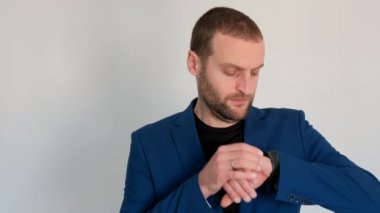 Mavi ceketli genç ve yakışıklı iş adamı kameraya bakıyor ve çalışıyor mu diye bakıyor.
