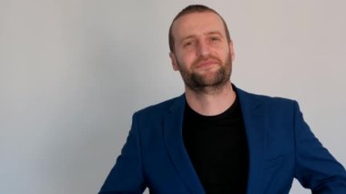 Mavi ceketli genç yakışıklı iş adamı kameraya baktı ve ceketini çıkardı.