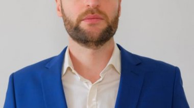 Mavi ceketli genç ve yakışıklı iş adamı kameraya konuşuyor.