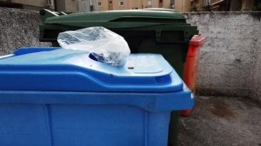 Plastik tankların arasındaki çöpün üstündeki su birikintisi.