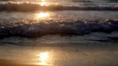 Bulanık odaklı video klibi güzel temiz plaj arkaplanı sarı gün batımında.