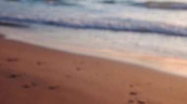 Bulanık odaklı video klibi güzel temiz plaj arkaplanı sarı gün batımında.