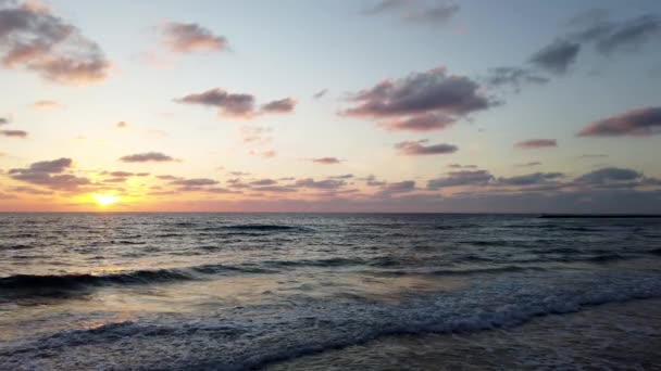 海水の上の日没の眺め 夕暮れ時のカラフルな空に黄金の太陽と海の波がビーチに突入 — ストック動画