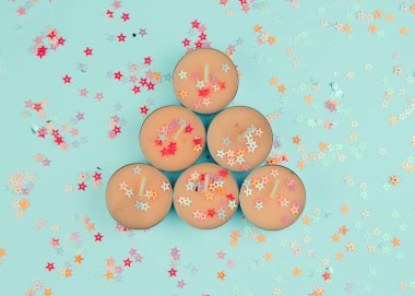 Işıltılı arka planda küçük mercan mumları. Doğum günü veya parti kartı kompozisyonu.