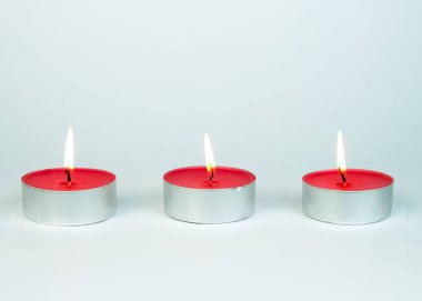 Beyaz arka planda izole edilmiş üç küçük pembe mum. Doğum günü veya parti kartı kompozisyonu.