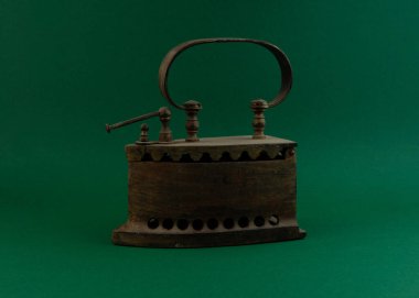 Yeşil arka planda kömürlerin üzerindeki eski model demir. Retro vintage tarzı.