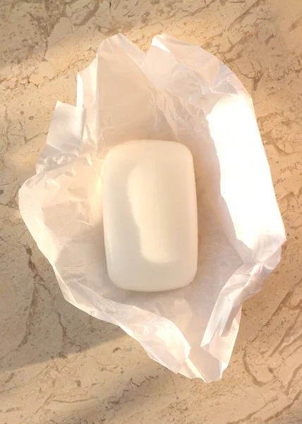 Sztanga mydła na białym papierze kraft na marmurowym stole. — Zdjęcie stockowe