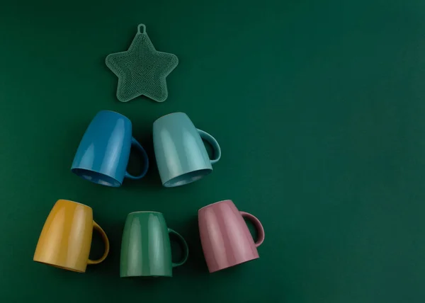 Alternative Christmas tree made of colorful cups on green background. Greeting card. Happy New Year and Merry christmas. — ストック写真