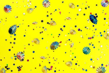 Sarı zemin üzerinde çok renkli parlak taşlar..