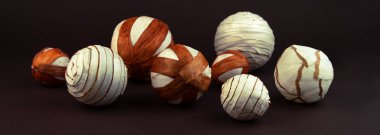 Kahverengi arka planda söğüt ağacından örülmüş dekoratif kürelerin geometrik bileşimi.