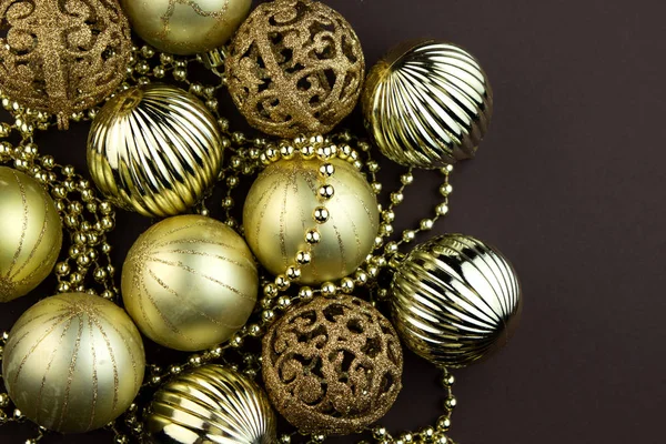 Золотые блестящие рождественские шары на коричневом фоне. Волшебная праздничная карта. Новогодняя или рождественская композиция . — стоковое фото