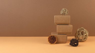 Noel geometrik afişi. Hediye kutuları, sarmaşık topları ve pastel kum rengi arka planda kuru portakal dilimleri..