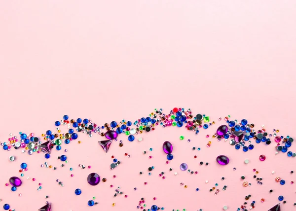 Mehrfarbige funkelnde Edelsteine auf pastellrosa Hintergrund. — Stockfoto