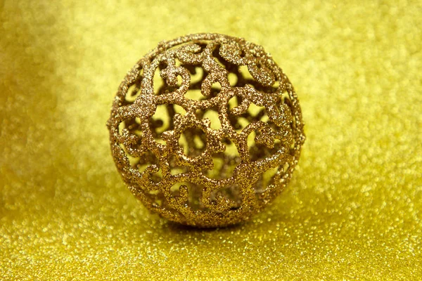 Golden christmas ball on glitter background. Close up.