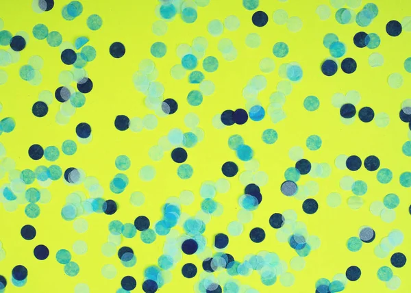 Slavnostní pestrobarevné konfety roztroušené na žlutém pozadí. Koncept dovolené. Pastelová puntíková textura. — Stock fotografie