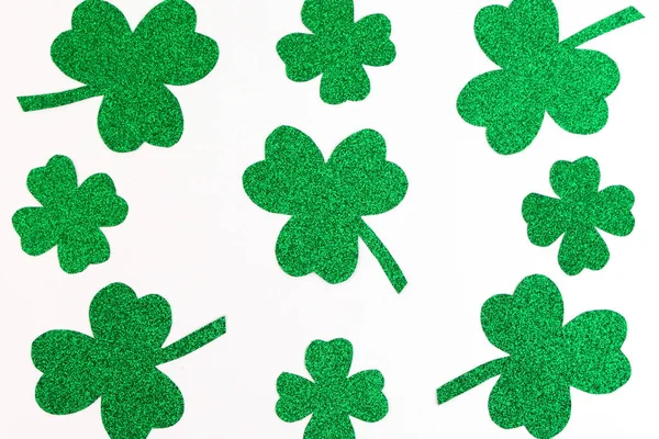 St.Patrick 's Day. Pattern of Clover shamrocks isolated on a white background. Glitter paper — Stock Photo, Image