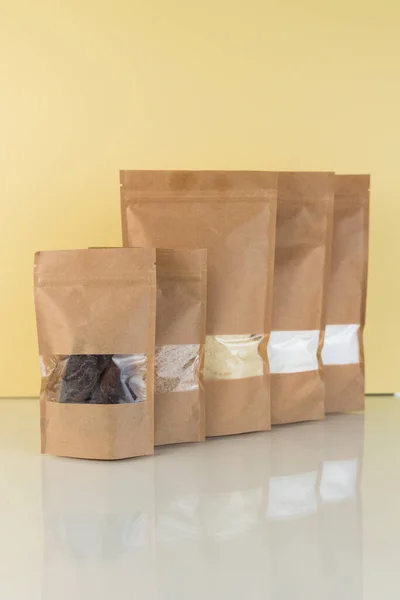 棕色牛皮纸袋 黄色背景上有杂货 食品和货物包装模板的模型 装有重量产品窗户的包装 — 图库照片