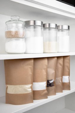 Kahverengi kraft kağıdından çanta ve sarı arka planda erzak. Gıda ve mallar için ambalaj tasarımı. Ağırlık ürünleri için pencereli paketler.