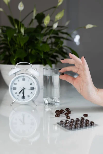 Vit Väckarklocka Och Medicinska Piller Med Ett Glas Vatten Bordet — Stockfoto