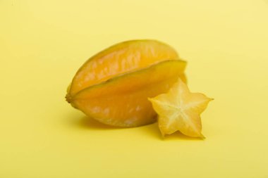 Yıldız meyveli karambola ya da sarı arka planda dilimlenmiş yıldız meyvesi. Sağlıklı meyve yemeği. Tropik meyve.