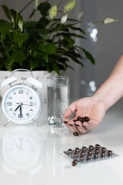 Vit Väckarklocka Och Medicinska Piller Med Ett Glas Vatten Bordet — Stockfoto