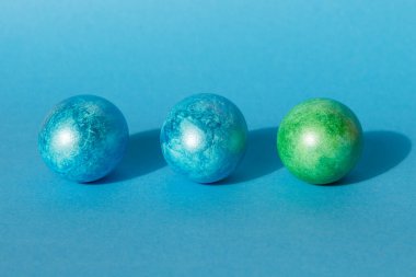 Mavi arka planda renkli paskalya yumurtaları. Mutlu Paskalya kompozisyonu. Boşluğu kopyala.