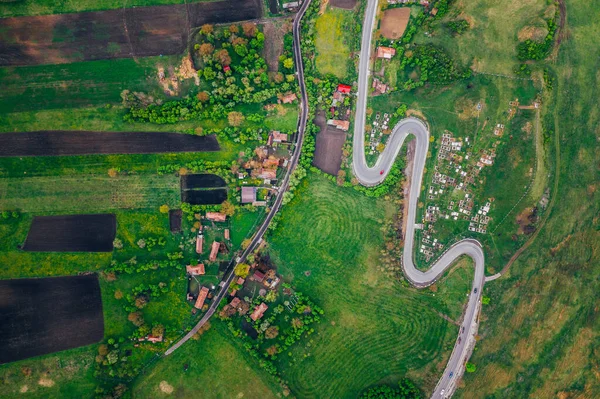 Curvy road from a drone view and agriculture fields