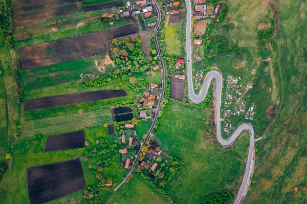 Curvy road from a drone view and agriculture fields