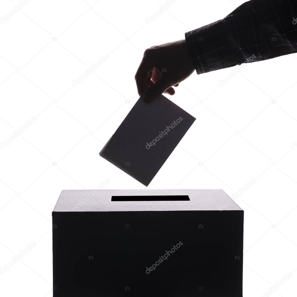 Silhouette of voter putting ballot into voting box. isolated background with copy-space