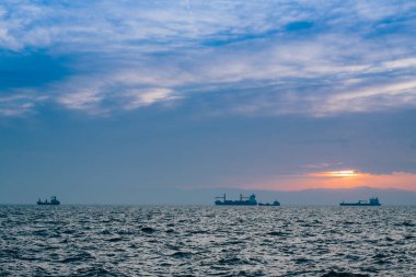 Fırtınadan sonra gün batımında bir gemiyle deniz manzarası