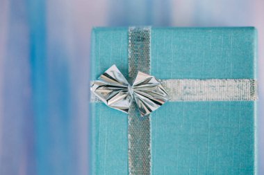 Pastel renklerle suluboya arka planda bir hediye kutusu.