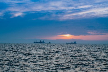 Fırtınadan sonra gün batımında bir gemiyle deniz manzarası