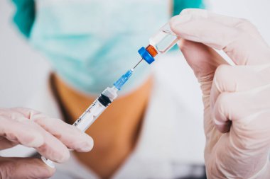 Aşı şişesi ve şırınga doktorların elinde. Covid-19 / Coronavirus konsepti. 