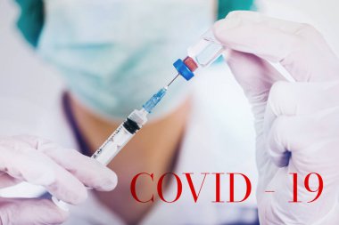 Aşı şişesi ve şırınga doktorların elinde. Covid-19 / Coronavirus konsepti. 