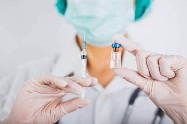 Aşı şişesi ve şırınga doktorların elinde. Covid-19 / Coronavirus konsepti. 