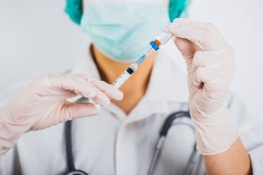Aşı şişesi ve şırınga doktorların elinde. Covid-19 / Coronavirus konsepti. 