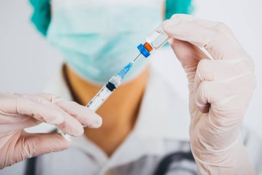Aşı şişesi ve şırınga doktorların elinde. Covid-19 / Coronavirus konsepti. 