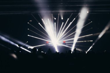 Sahne ışıkları ve bir müzik festivalinde elleri havada seyirci kalabalığı. Taraftarlar parti havasını seviyor.