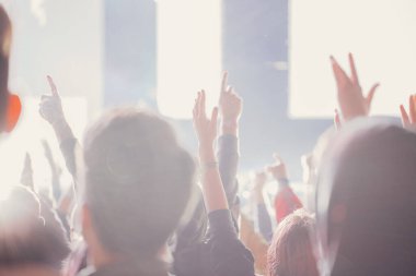 Sahne ışıkları ve bir müzik festivalinde elleri havada seyirci kalabalığı. Taraftarlar parti havasını seviyor.