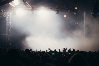 Sahne ışıkları ve bir müzik festivalinde elleri havada seyirci kalabalığı. Taraftarlar parti havasını seviyor.