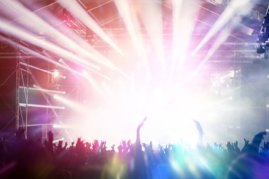 Sahne ışıkları ve bir müzik festivalinde elleri havada seyirci kalabalığı. Taraftarlar parti havasını seviyor.