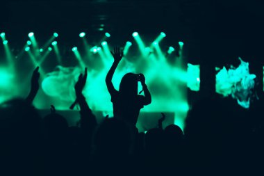 Sahne ışıkları ve bir müzik festivalinde elleri havada seyirci kalabalığı. Taraftarlar parti havasını seviyor.
