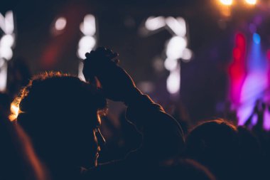 Sahne ışıkları ve bir müzik festivalinde elleri havada seyirci kalabalığı. Taraftarlar parti havasını seviyor.