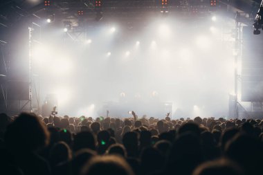 Sahne ışıkları ve bir müzik festivalinde elleri havada seyirci kalabalığı. Taraftarlar parti havasını seviyor.