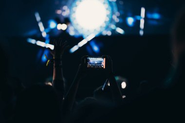 Sahne ışıkları ve bir müzik festivalinde elleri havada seyirci kalabalığı. Taraftarlar parti havasını seviyor.