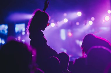 Sahne ışıkları ve bir müzik festivalinde elleri havada seyirci kalabalığı. Taraftarlar parti havasını seviyor.