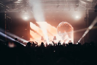 Sahne ışıkları ve bir müzik festivalinde elleri havada seyirci kalabalığı. Taraftarlar parti havasını seviyor.
