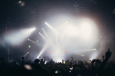 Sahne ışıkları ve bir müzik festivalinde elleri havada seyirci kalabalığı. Taraftarlar parti havasını seviyor.