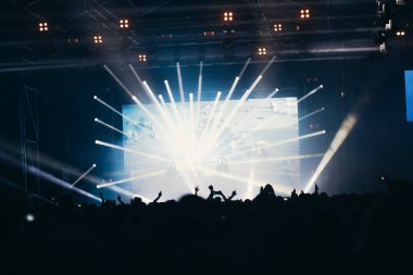 Sahne ışıkları ve bir müzik festivalinde elleri havada seyirci kalabalığı. Taraftarlar parti havasını seviyor.