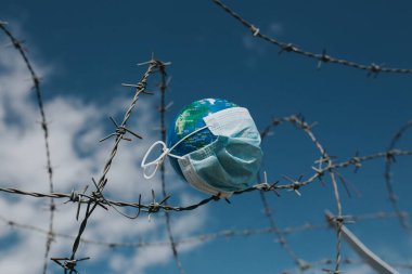 Dünya 'daki cerrahi maske. Salgın hastalık konsepti. Covid-19 / Coronavirus virüsü bulaşmış bir dünya. 